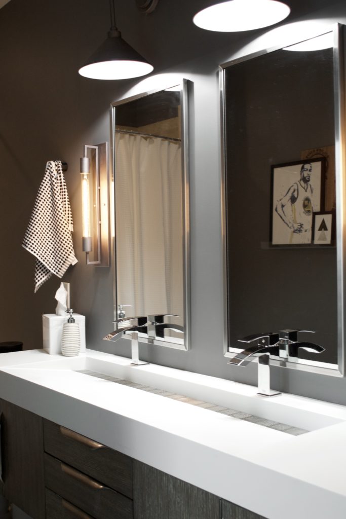 Our Encore Condo project features a modern masculine owner's bathroom with a wall-mounted double floating vanity and 4" thick integrated matte white trough sink against dark gray walls. #modernmasculine #ownersbathroom #condobathrooms #BehrAsphaltGray