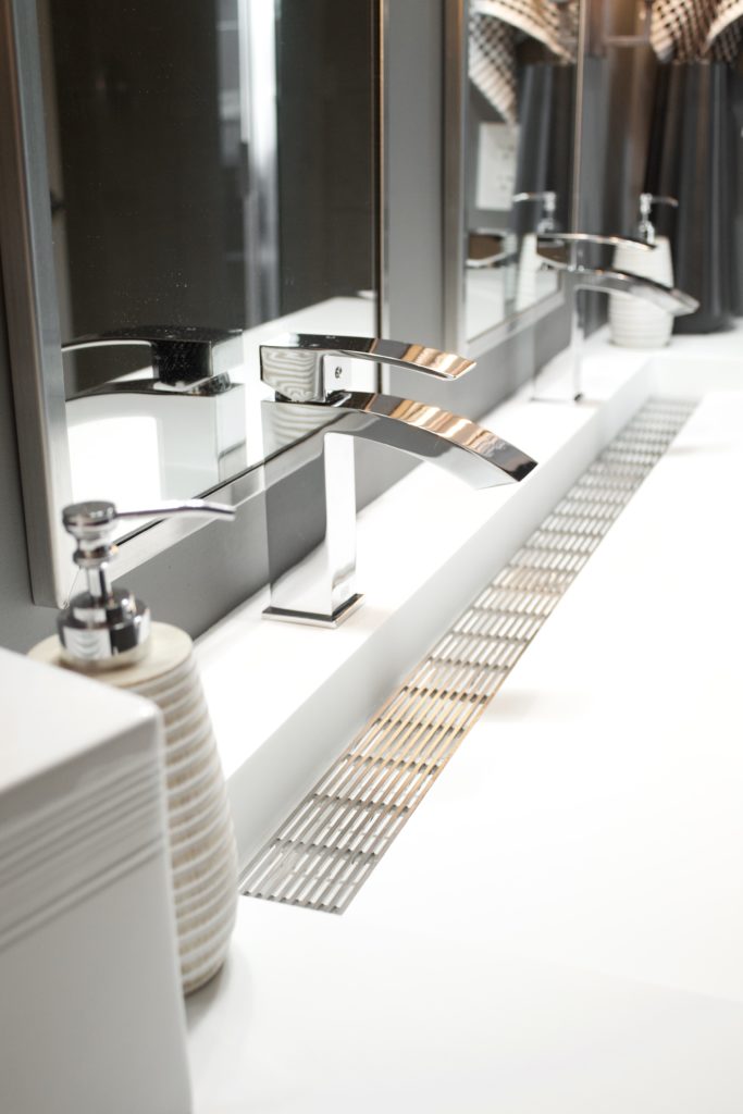 Our Encore Condo project features a modern masculine owner's bathroom with a wall-mounted double floating vanity and 4" thick integrated matte white trough sink against dark gray walls. #modernmasculine #ownersbathroom #condobathrooms #BehrAsphaltGray