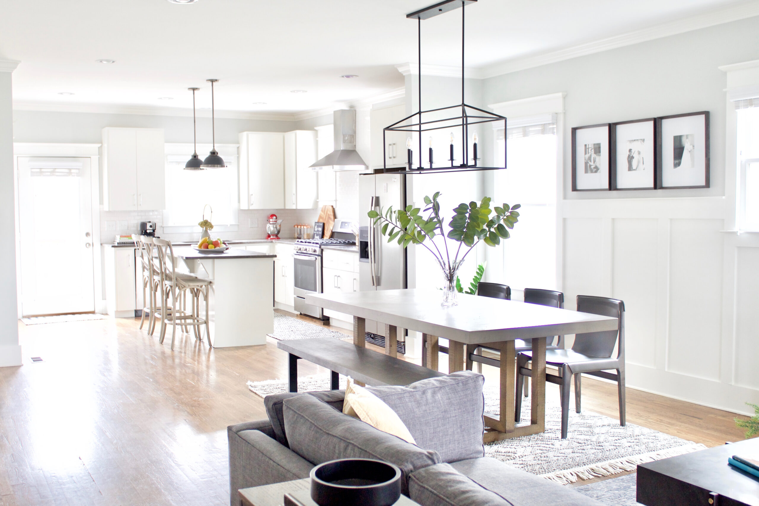 Our #GreenwoodAvenueRemodel project features a contemporary craftsman style eat-in kitchen with an open concept that flows directly into the living room and entry. We updated the space by painting the cabinets white, the walls a light gray, and adding new light fixtures and furnishings. #contemporarycraftsman #PPGTornado #eatinkitchens 