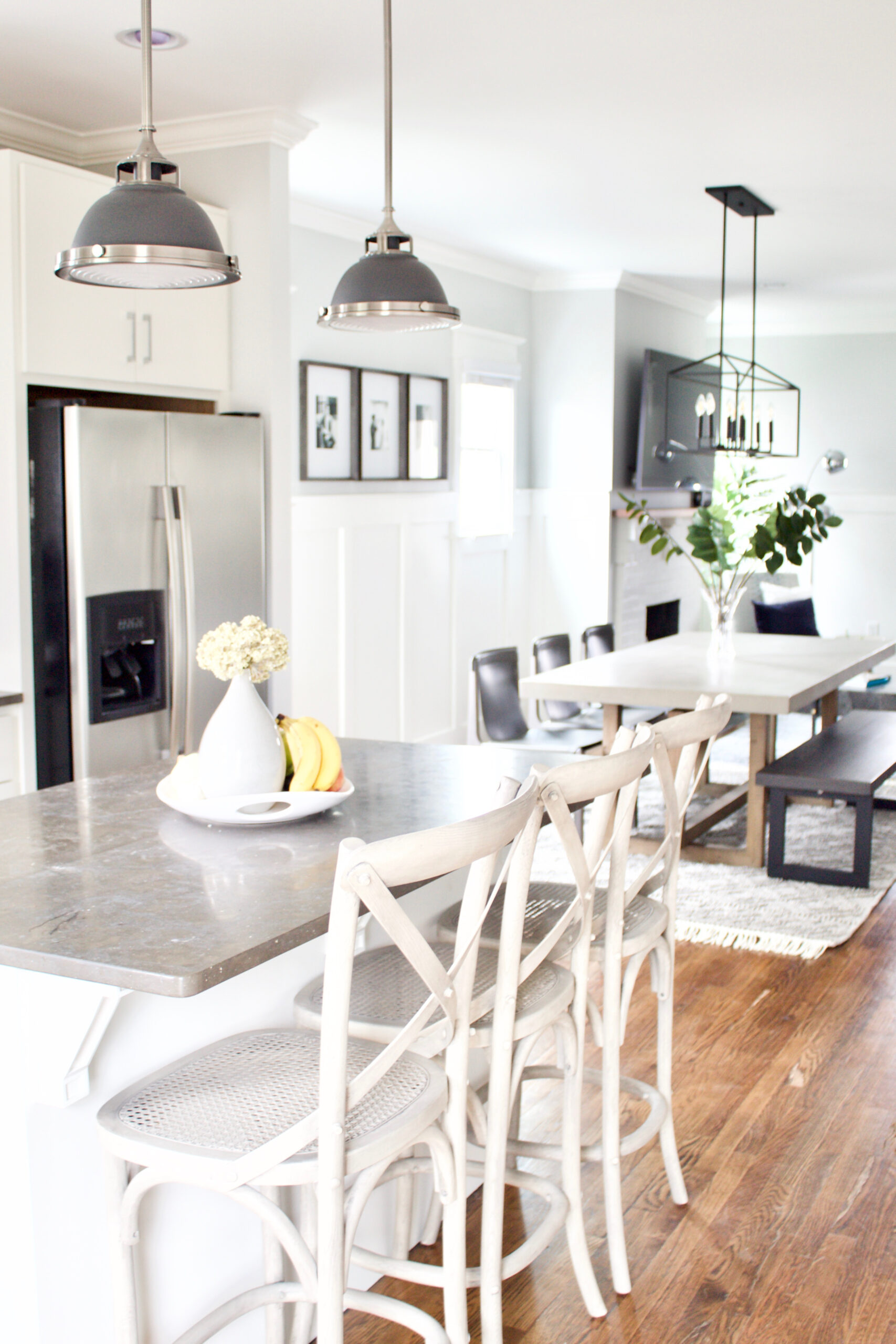 Our #GreenwoodAvenueRemodel project features a contemporary craftsman style eat-in kitchen with an open concept that flows directly into the living room and entry. We updated the space by painting the cabinets white, the walls a light gray, and adding new light fixtures and furnishings. #contemporarycraftsman #PPGTornado #eatinkitchens 