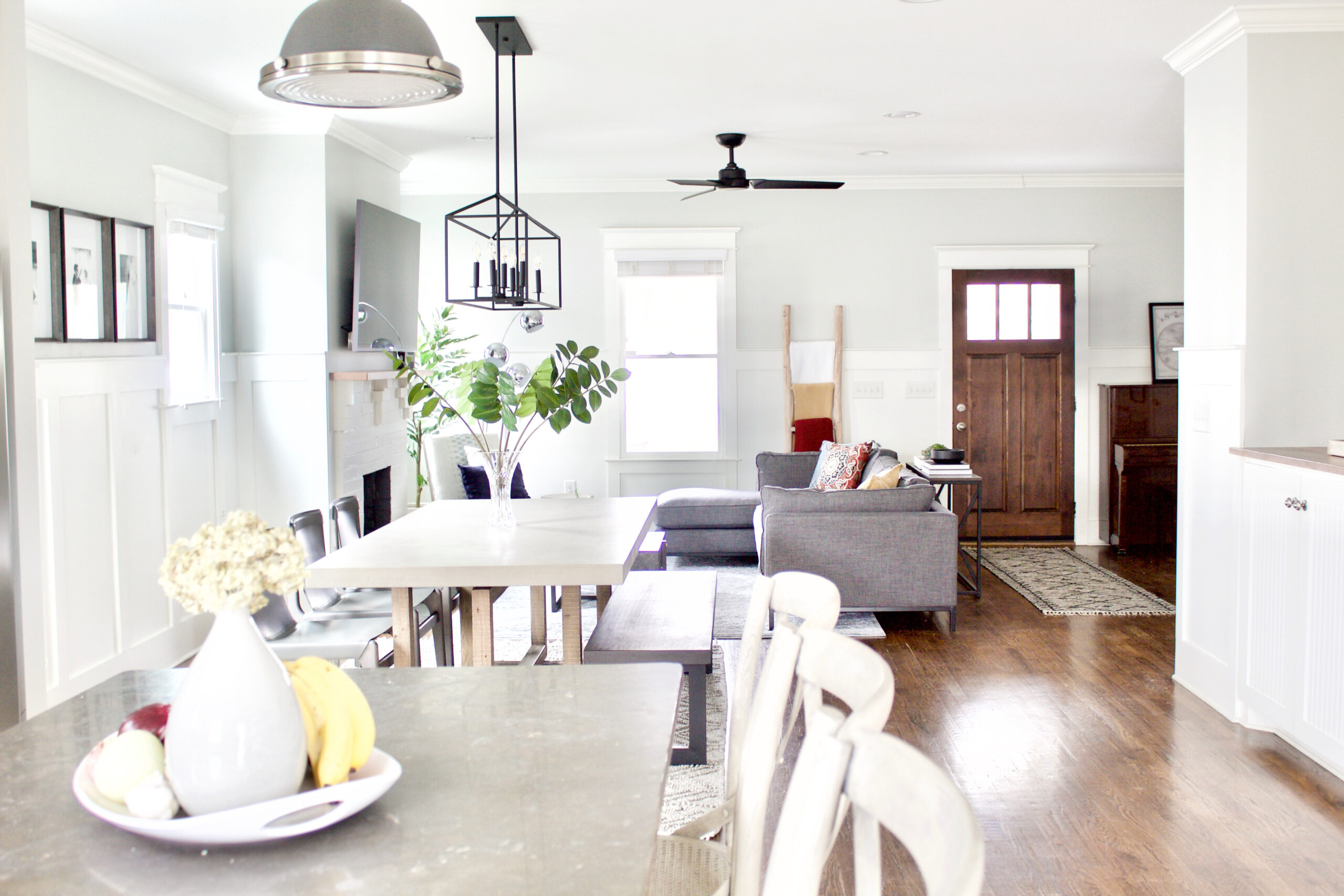 Our #GreenwoodAvenueRemodel project features a contemporary craftsman style eat-in kitchen with an open concept that flows directly into the living room and entry. We updated the space by painting the cabinets white, the walls a light gray, and adding new light fixtures and furnishings. #contemporarycraftsman #PPGTornado #eatinkitchens 